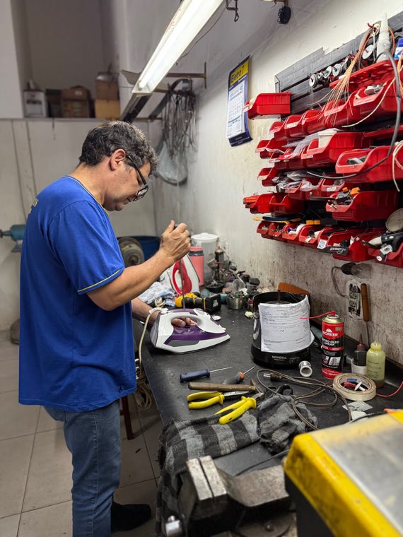 Técnico na bancada de reparos da oficina